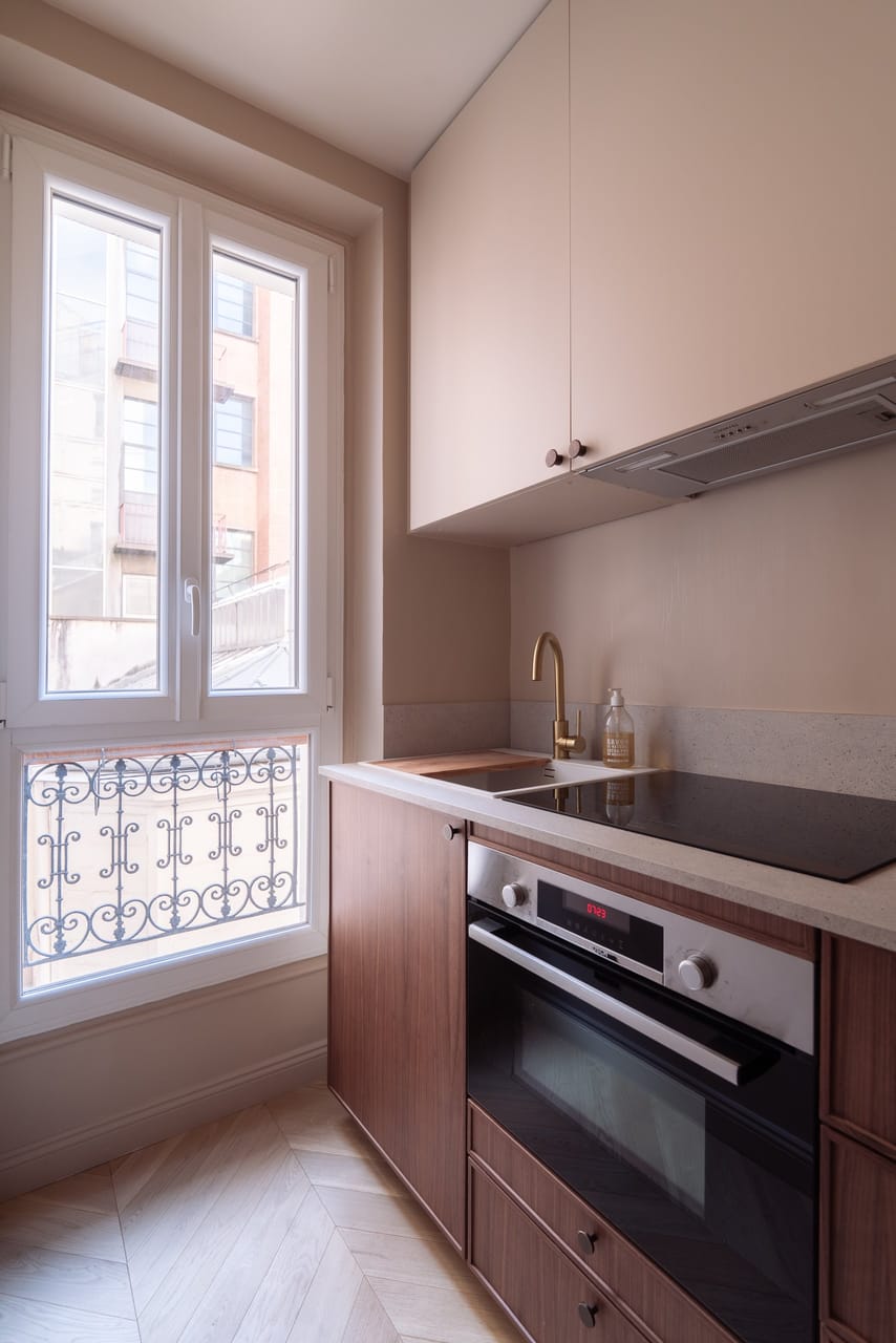 Cuisine équipée, plaque et fenêtre à balcon en fer forgé